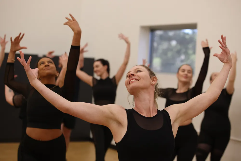 A Fitesque class mid-routine, arms in the air