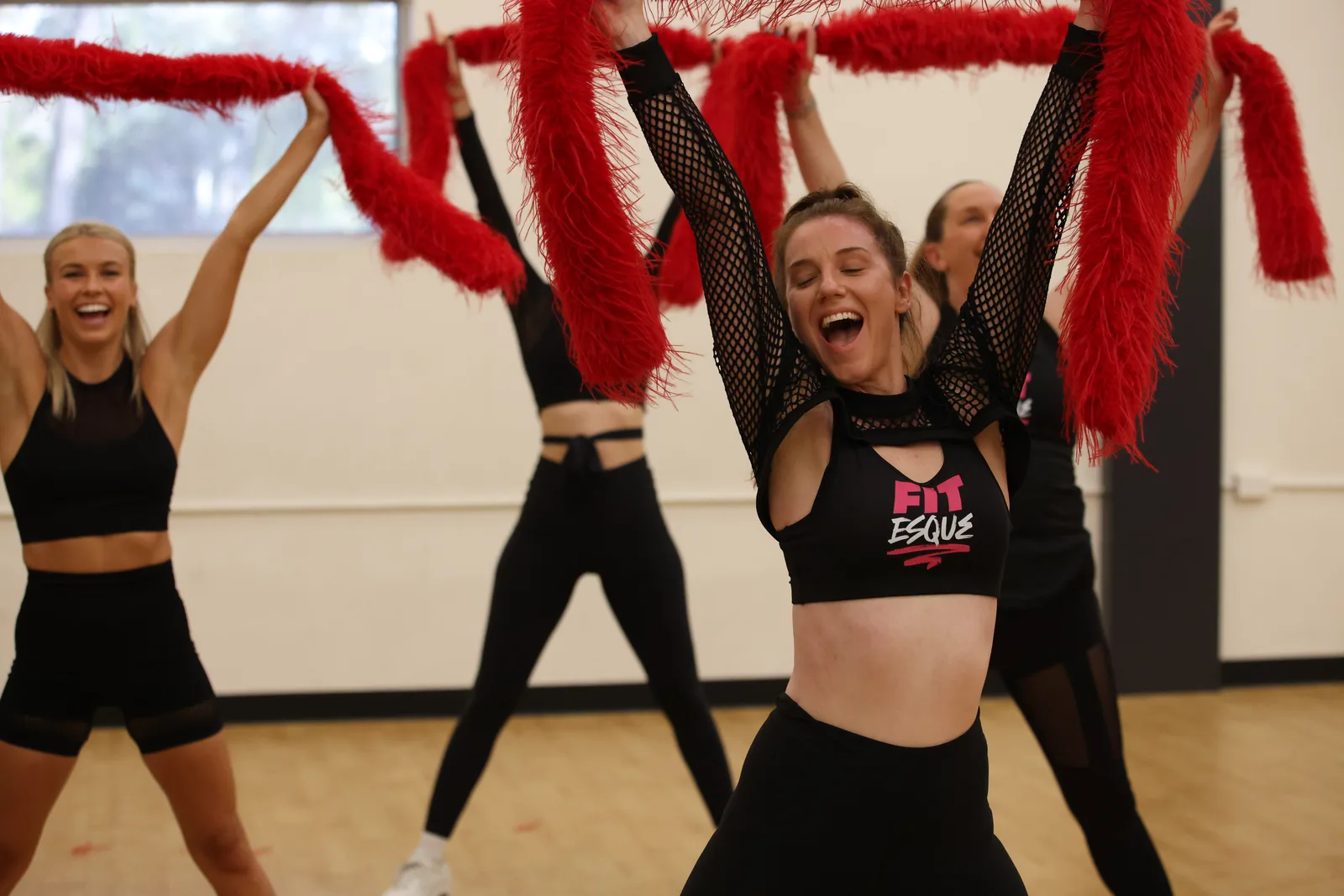 A Fitesque class with boas held overhead